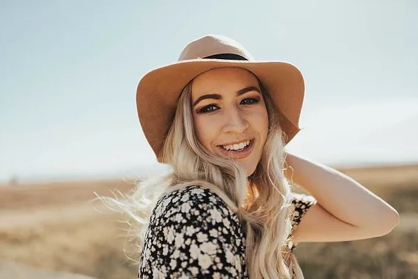 Photo of Paige smiling outside in a sunhat